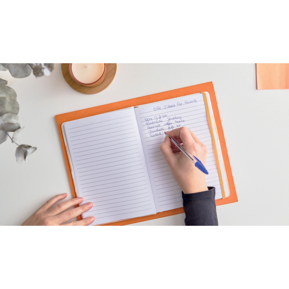 notebook, offenes notizbuch, oranger deckel, lineierte seiten, schreibende hand