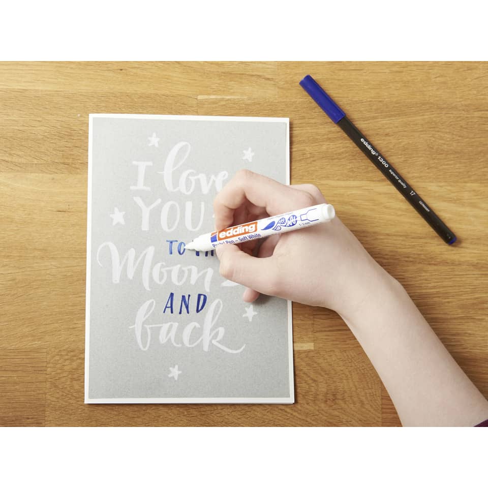 handwritten card, whiteboard marker, card with script, pens on desk, brown wooden surface